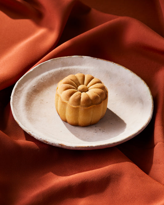 Red bean mini  mooncake on a white plate with a red cloth background